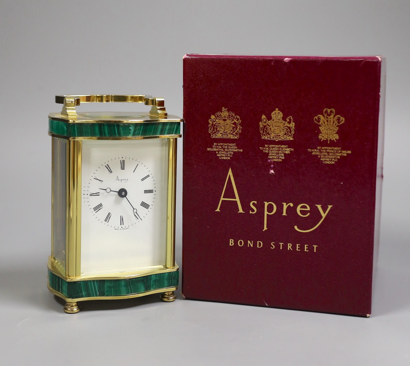 An Asprey carriage timepiece with key, 12 cms high, and an Asprey presentation box